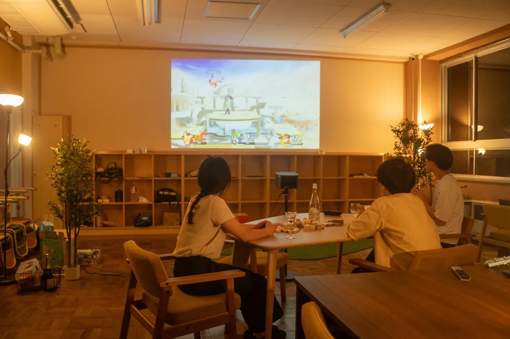 夜、教室の壁にプロジェクターで映像を映している様子