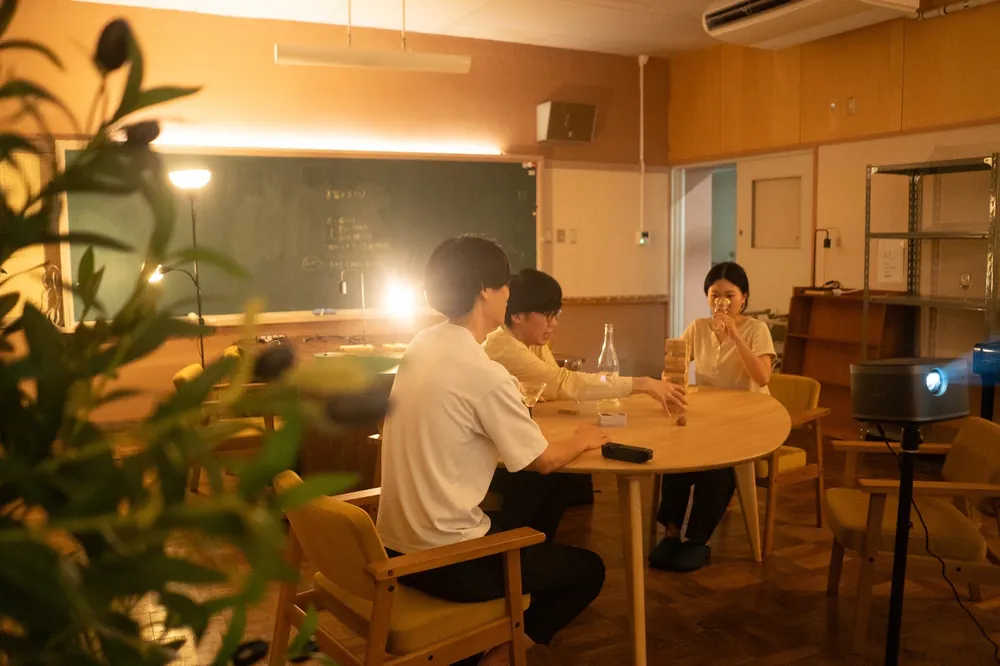 夜、間接照明の下でテーブルを囲む人たち